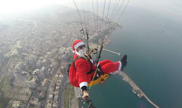 Noel Baba kostümüyle Amanoslar'dan yamaç paraşütüyle atlayıp çocuklara hediye dağıttı