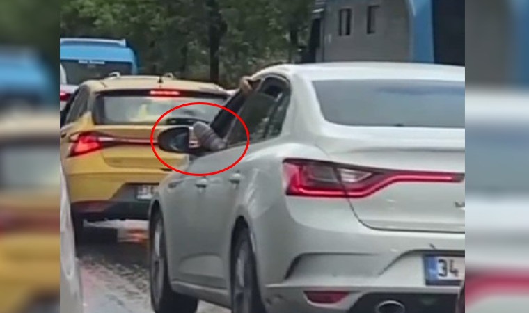 Ayağını camdan çıkararak otomobil kullanan sürücü kamerada