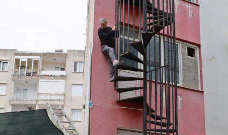 Yarım kalan yangın merdiveninde mahsur kaldı