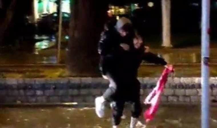 İki genç yağmur sularına düşen Türk bayrağını aldı