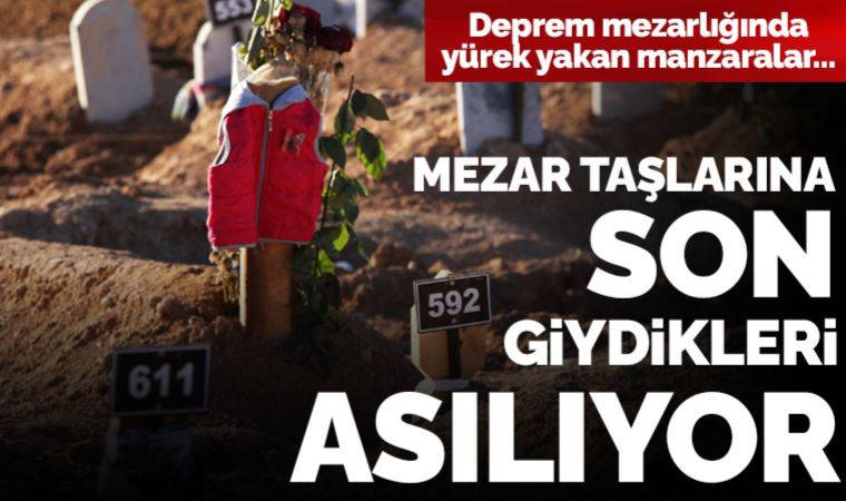 Deprem mezarlığında yürek yakan manzaralar: Mezar taşlarına son giydikleri asılıyor....