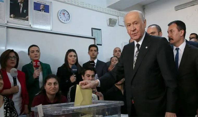 Bahçeli oy kullanırken bir genç arkasından kalp işareti yaptı