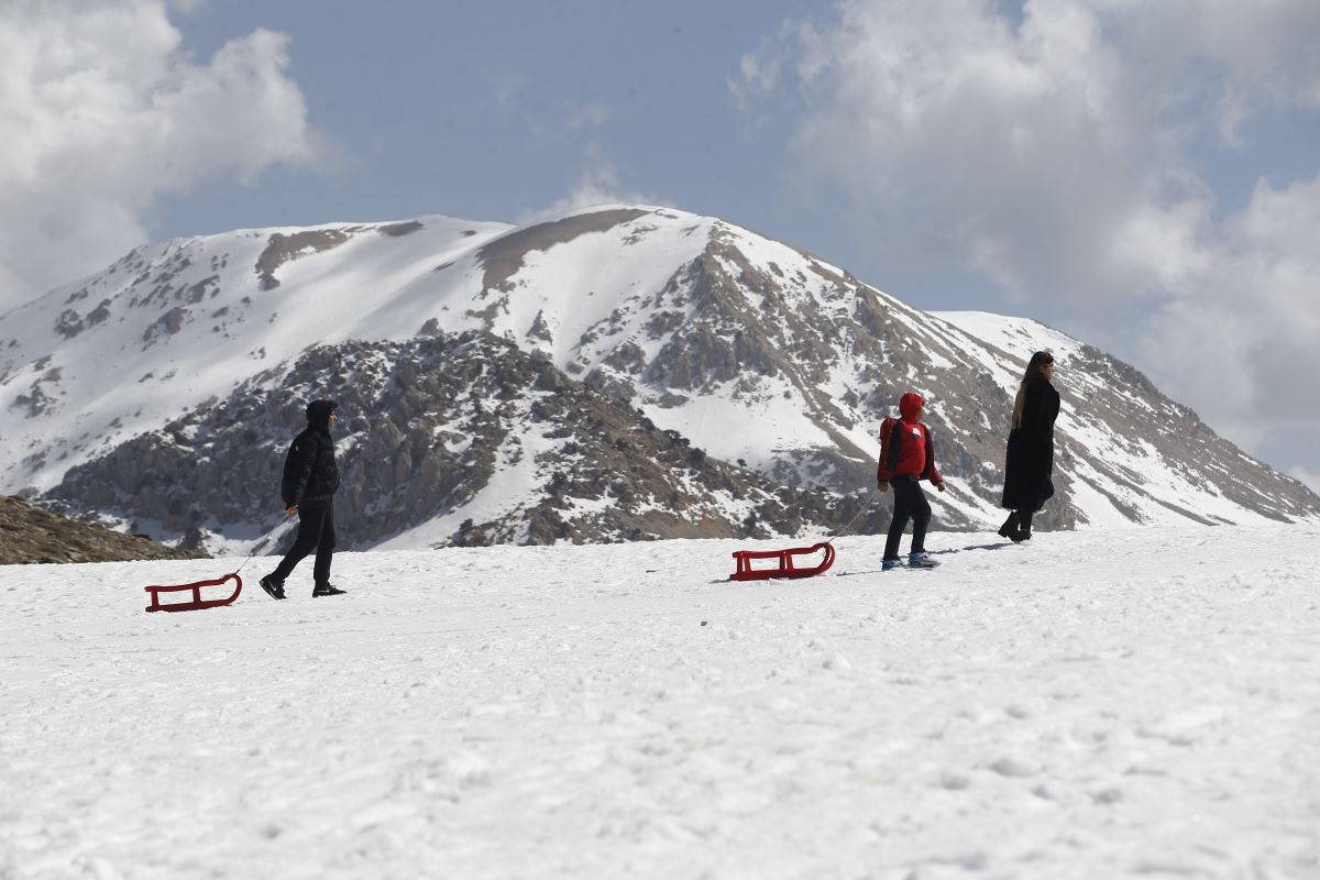 Antalya'da zirvede kış sporları yapılırken sahilde denize girenler oldu