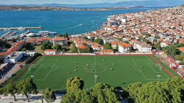 Ağaçların gölgesinde deniz manzaralı tribünde maç keyfi