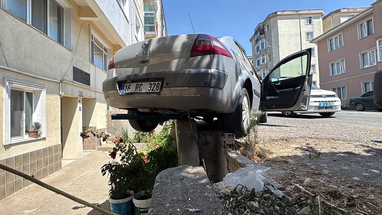 Car Rolls Back and Gets Stuck on Retaining Wall After Driver Forgets Parking Brake